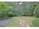 Sprawling green backyard with mature trees and stone paver path at 120 Hamilton Glen Ct, Fayetteville, GA 30215