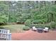 Relaxing brick patio with outdoor seating and fire pit, surrounded by lush greenery at 120 Hamilton Glen Ct, Fayetteville, GA 30215