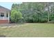 Sprawling green backyard with mature trees and a black fence at 120 Hamilton Glen Ct, Fayetteville, GA 30215