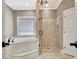 Bright bathroom featuring a soaking tub, glass enclosed shower, and natural lighting at 120 Hamilton Glen Ct, Fayetteville, GA 30215