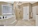 Bright bathroom featuring a soaking tub, glass enclosed shower, and custom cabinetry at 120 Hamilton Glen Ct, Fayetteville, GA 30215