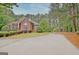 A long driveway winds through lush greenery, leading up to a charming brick home at 120 Hamilton Glen Ct, Fayetteville, GA 30215