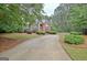 A long driveway winds through lush greenery, leading up to a charming brick home at 120 Hamilton Glen Ct, Fayetteville, GA 30215