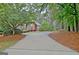 A long driveway winds through lush greenery, leading up to a charming brick home at 120 Hamilton Glen Ct, Fayetteville, GA 30215