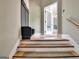 Staircase leading to a entryway featuring coat rack and view to screened porch at 120 Hamilton Glen Ct, Fayetteville, GA 30215
