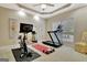 Bright exercise room with ceiling fan, treadmill, stationary bike, and large window with natural light at 120 Hamilton Glen Ct, Fayetteville, GA 30215