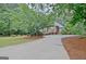 A glimpse of the brick home from the driveway showcases the landscape of the property at 120 Hamilton Glen Ct, Fayetteville, GA 30215