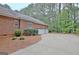Side view of a brick two-car garage featuring adjacent landscaping and driveway at 120 Hamilton Glen Ct, Fayetteville, GA 30215