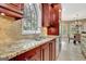 A sink sits beneath a custom window in this kitchen with granite countertops and cherry cabinets at 120 Hamilton Glen Ct, Fayetteville, GA 30215