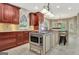 Spacious kitchen featuring cherry wood cabinets, a large island, and stainless steel appliances at 120 Hamilton Glen Ct, Fayetteville, GA 30215