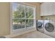 Bright laundry room with modern stainless steel washer and dryer and storage cabinets at 120 Hamilton Glen Ct, Fayetteville, GA 30215