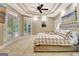 Bright main bedroom featuring a tray ceiling, ceiling fan, and balcony access at 120 Hamilton Glen Ct, Fayetteville, GA 30215