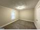 Clean bedroom featuring plush carpet, neutral walls, a single window, and trim along the ceiling at 4162 Mercer Rd, Decatur, GA 30035