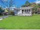 Charming painted brick home featuring a covered front porch and a well-manicured lawn at 4162 Mercer Rd, Decatur, GA 30035