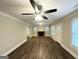 Spacious living room featuring a brick fireplace, updated ceiling fan, and sleek, dark wood-look flooring at 4162 Mercer Rd, Decatur, GA 30035