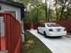A white car sits on a paved driveway next to a red fence at 3479 Thompson Nw Dr, Atlanta, GA 30331