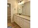 Well-lit bathroom with granite countertop vanity, framed mirror, and wood floors at 1685 Crumbley Rd # 4, Mcdonough, GA 30252