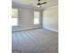 Spacious bedroom with neutral walls, gray carpet, two windows and modern ceiling fan at 1685 Crumbley Rd # 4, Mcdonough, GA 30252
