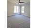 Spacious bedroom with neutral walls, gray carpet, two windows and modern ceiling fan at 1685 Crumbley Rd # 4, Mcdonough, GA 30252