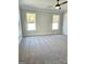 Spacious bedroom with neutral walls, gray carpet, two windows and modern ceiling fan at 1685 Crumbley Rd # 4, Mcdonough, GA 30252