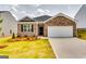 Charming brick home with a manicured lawn and a two-car garage under a cloudy sky at 616 Whitman Ln # 30, Stockbridge, GA 30281