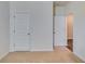 Neutral-colored carpeted hallway with bright white walls, with many doors leading to other rooms at 616 Whitman Ln # 30, Stockbridge, GA 30281