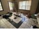 Untidy living room showcasing black and white checkered floors, a rocking chair, and a bright window view at 530 Whitley Dr, Forest Park, GA 30297