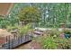 Backyard with a bridge over a garden, leading to lush landscaping, a pond, and a barn at 104 Whisper Trce, Peachtree City, GA 30269
