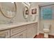 Bright bathroom boasts double vanity with granite counters, oval mirrors, and wood cabinets, exuding modern elegance at 104 Whisper Trce, Peachtree City, GA 30269