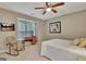 Cozy bedroom features a rocking chair, desk near a window, and a comfortable bed with a TV for relaxation at 104 Whisper Trce, Peachtree City, GA 30269