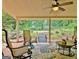 Relaxing covered patio with seating and peaceful views of the lush gardens with a small bridge at 104 Whisper Trce, Peachtree City, GA 30269