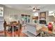 Open living room featuring a fireplace, ceiling fan, hardwood floors, and patio access at 104 Whisper Trce, Peachtree City, GA 30269