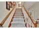 Carpeted staircase with wooden handrail and white spindles, leading to upper level at 104 Whisper Trce, Peachtree City, GA 30269