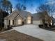 Exterior view shows large driveway leading to home with lights on at 1007 Fairway Seven, Villa Rica, GA 30180