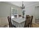 Dining room with chandelier, wood chairs, and backyard view from a large window at 125 Wendell Ct, Fayetteville, GA 30215