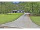 View of the home showing the long driveway, mature trees and well-maintained lawn at 125 Wendell Ct, Fayetteville, GA 30215