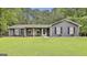 Charming single-story home with a well-manicured lawn, covered porch, and gray siding at 125 Wendell Ct, Fayetteville, GA 30215