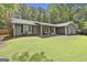 Front exterior showcasing a well-maintained lawn and charming covered porch with chairs at 125 Wendell Ct, Fayetteville, GA 30215