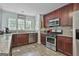 View of the kitchen featuring stainless steel appliances, granite countertops, and dark wood cabinetry at 125 Wendell Ct, Fayetteville, GA 30215
