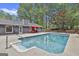 Large in-ground swimming pool is surrounded by patio space and lush greenery, perfect for summer fun at 125 Wendell Ct, Fayetteville, GA 30215