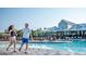 A resort-style community pool with a couple walking by, featuring ample seating and a well-maintained pool deck at 430 Silverbell Ct, Peachtree City, GA 30269