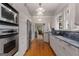 Bright, galley kitchen featuring stainless steel appliances, hardwood floors, and white cabinets at 239 Kings Hwy, Decatur, GA 30030