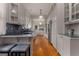 Bright, white galley kitchen featuring an island with seating, stainless appliances, and hardwood floors at 239 Kings Hwy, Decatur, GA 30030