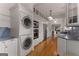 Modern laundry room featuring a stacked washer and dryer, and white cabinets and sink at 239 Kings Hwy, Decatur, GA 30030