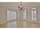 Inviting dining room featuring hardwood floors, elegant lighting, and plantation shutters for natural light at 112 Windalier Rdg, Peachtree City, GA 30269