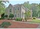 Beautifully designed home featuring manicured shrubbery, a gray stucco finish, and an arched window at 112 Windalier Rdg, Peachtree City, GA 30269