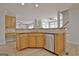 Bright kitchen with a stainless steel dishwasher and an open view to the dining and living areas at 112 Windalier Rdg, Peachtree City, GA 30269