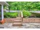 Backyard with a brick retaining wall, stairs, and lush plantings at 1880 Hickory Station Cir, Snellville, GA 30078