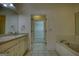 Bathroom featuring a tub, an open walk-in closet, double sinks, and white tiled floors at 1880 Hickory Station Cir, Snellville, GA 30078