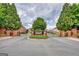 Gated community entrance with brick pillars, mature trees, and professional landscaping at 1880 Hickory Station Cir, Snellville, GA 30078